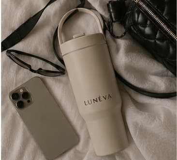 Oat LUNÉVA bottle packed beside a phone and bag